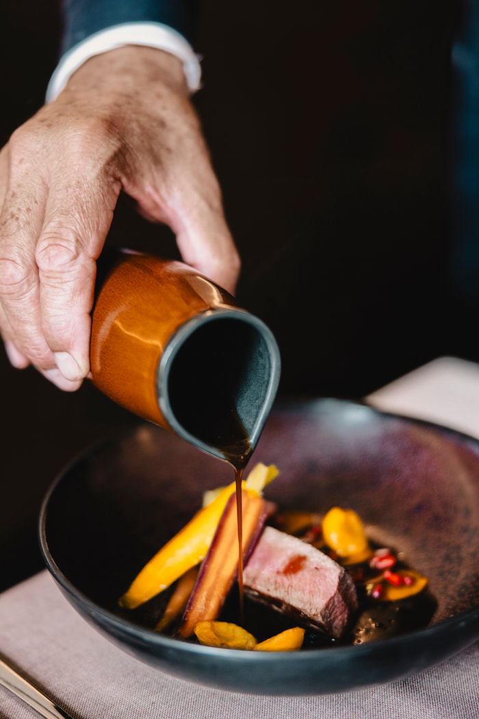 Hohe Komposition des Restaurant-Ambientes: vertikale Sicht des Speisebereichs mit eleganter Dekoration und stimmungsvoller Beleuchtung.